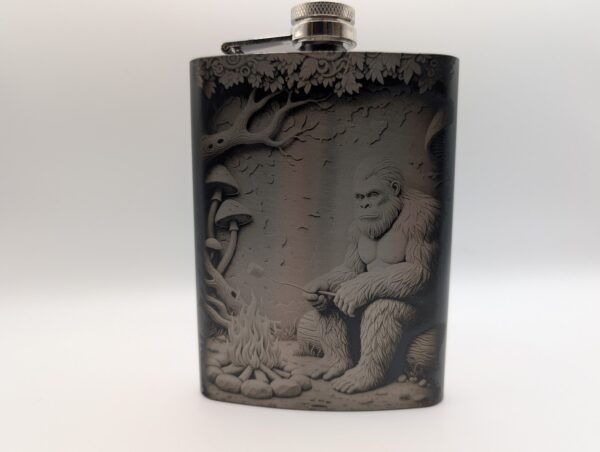 Bigfoot sitting next to a fire roasting marshmallows - design on a flask